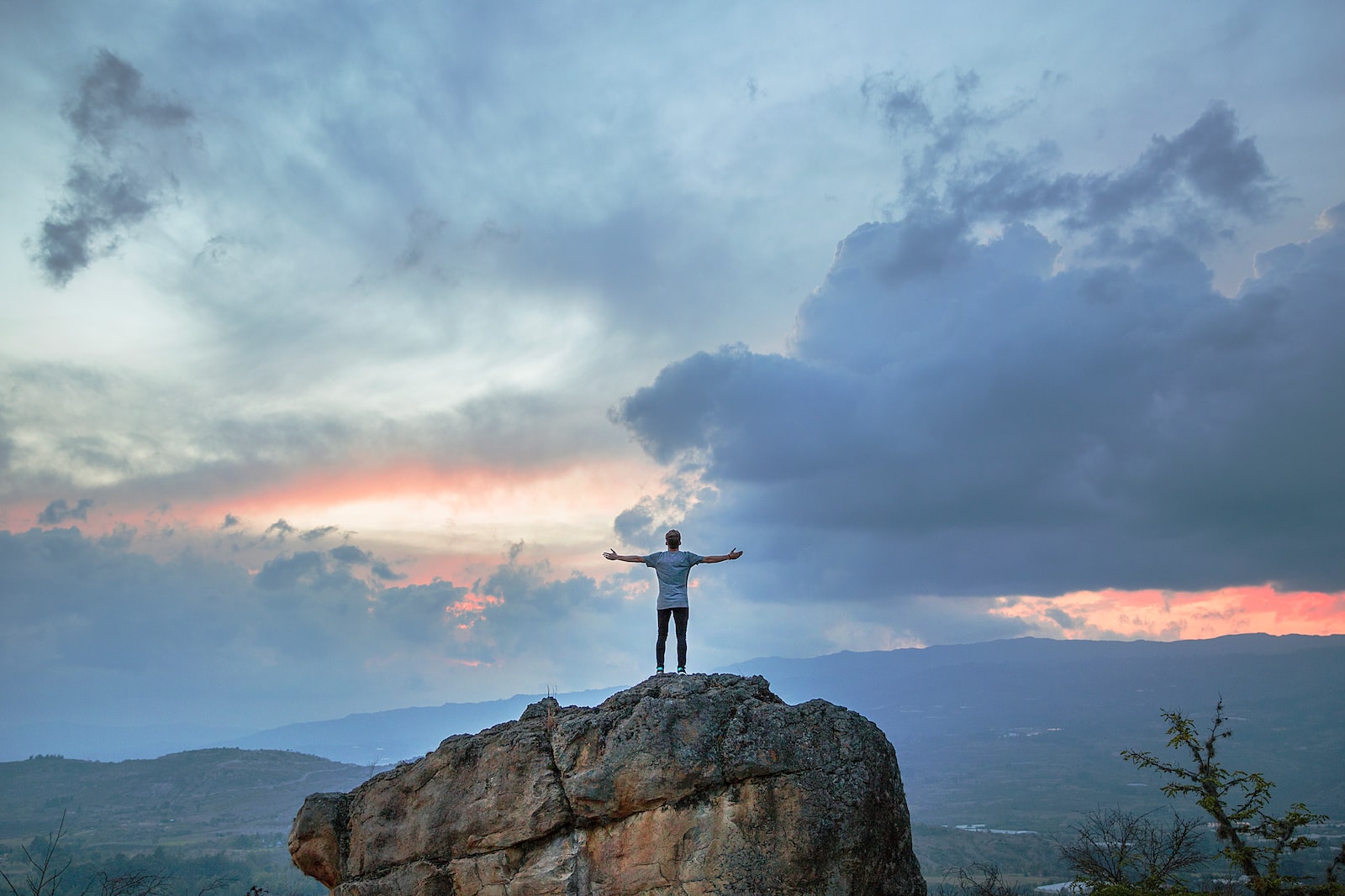 homme libre sur un rocher , coucher de soleil