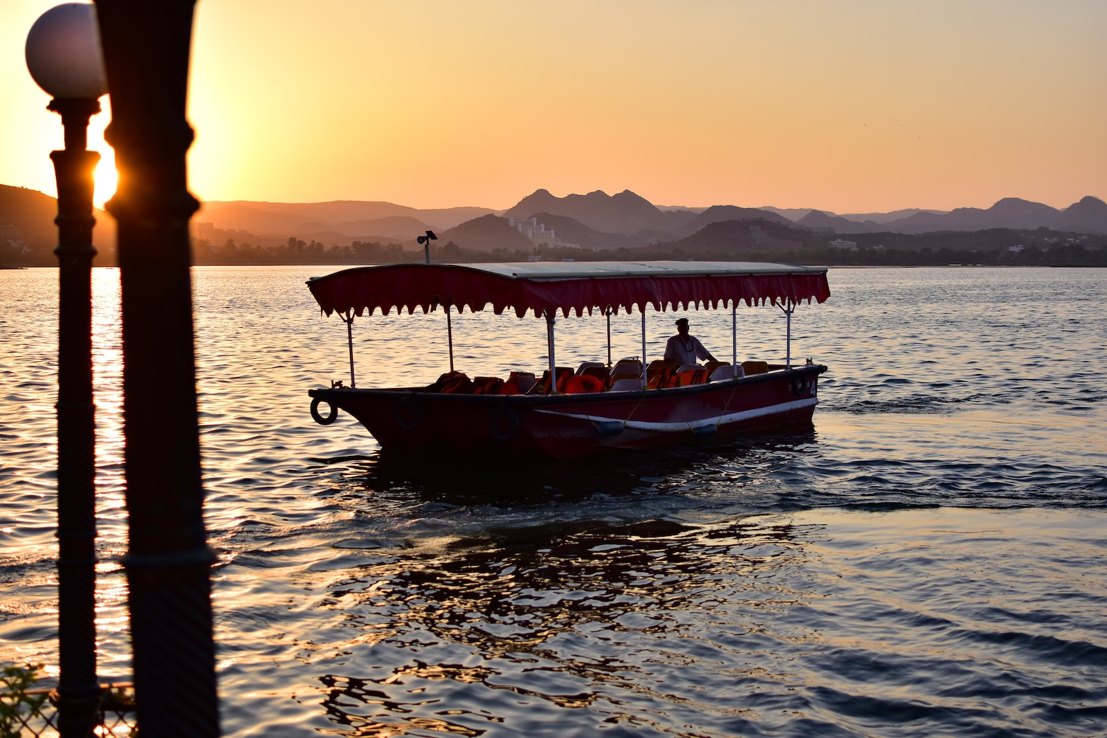 homme sur un bateau en Inde, beau coucher de soleil