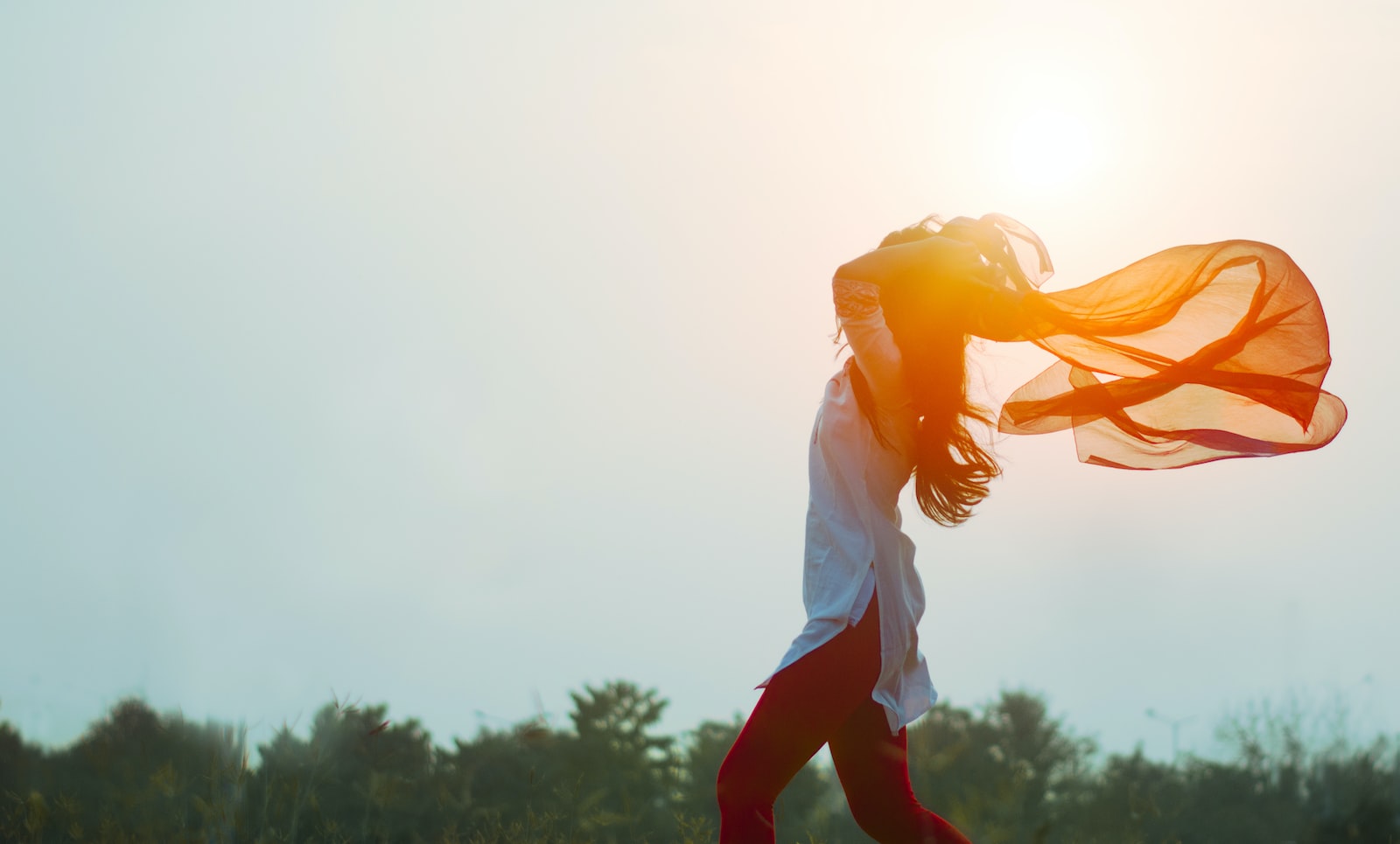 Femme libre sous le coucher de soleil