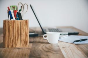bureau avec un ordinateur, tasse de café et pot de crayon