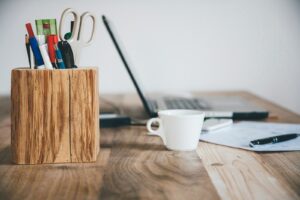 bureau avec un ordinateur, tasse de café et pot de crayon
