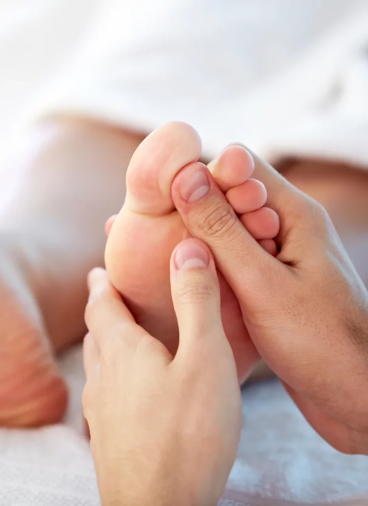 Réflexologue massant un pied avec les mains