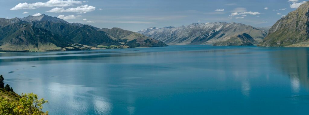 lac bleu près de la montagne couverte de neige pendant la journée