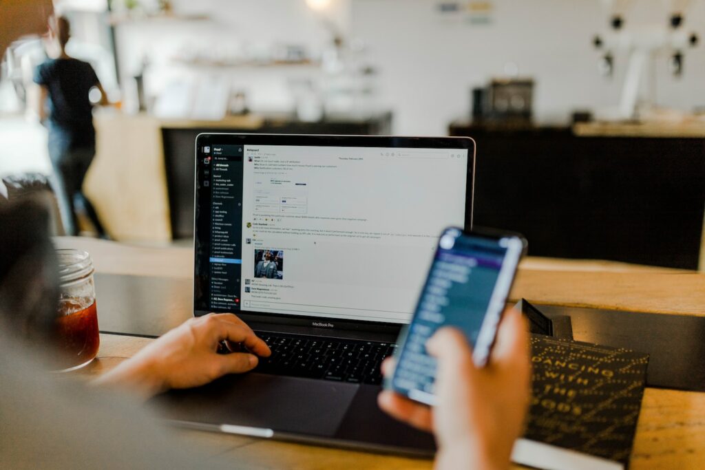 personne utilisant son téléphone et son ordinateur, canaux de communication