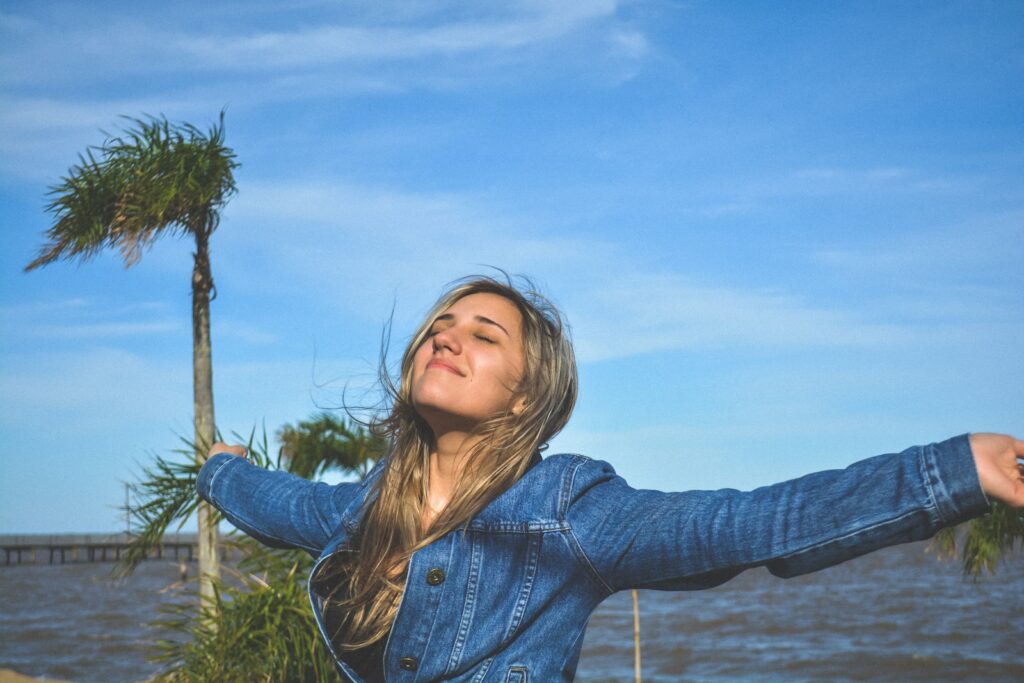 femme heureuse avec les bras ouverts sous le ciel bleu