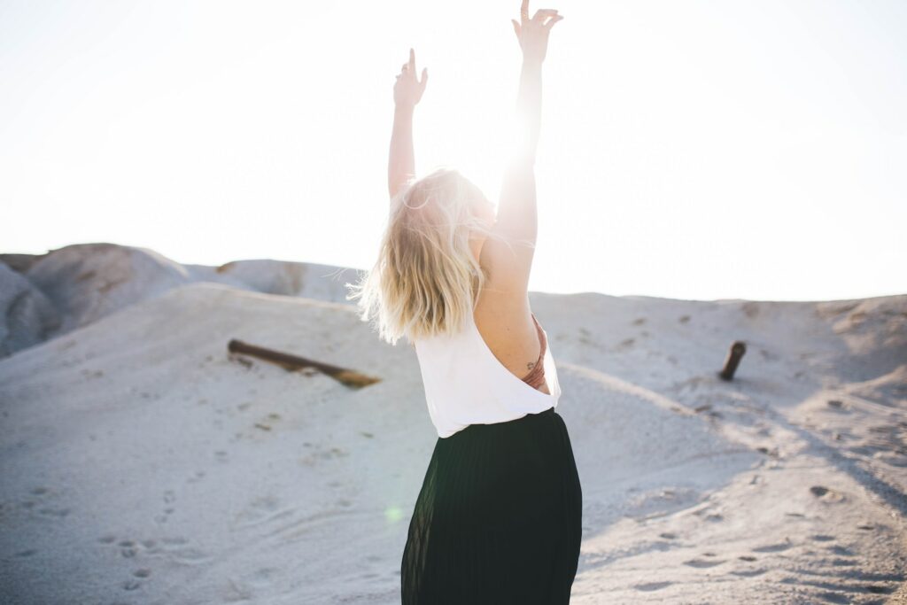 booster sa confiance, femme qui leve les bras sur la plage