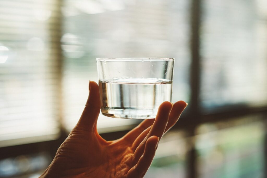 personne qui tient un verre d'eau