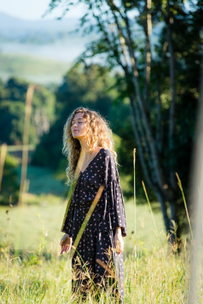 woman in black long-sleeved dress standing on grass field